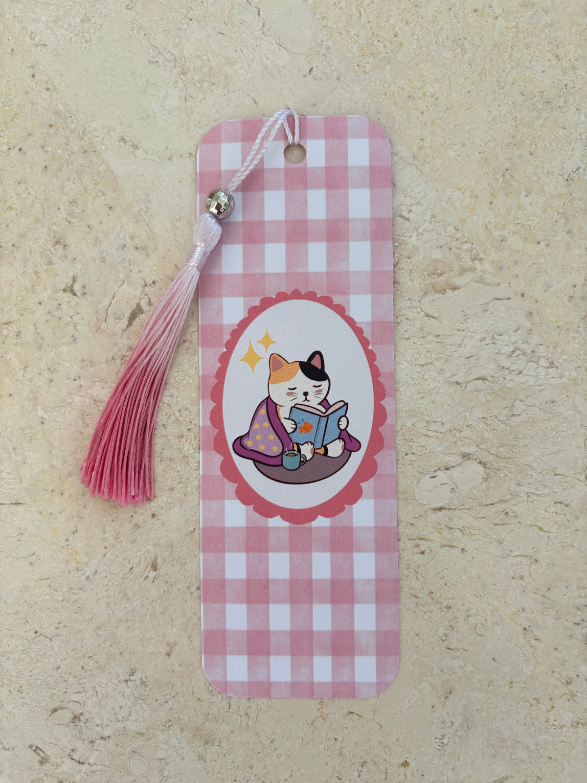 Pink gingham bookmark featuring a cute cat reading a book with a pink tassel.