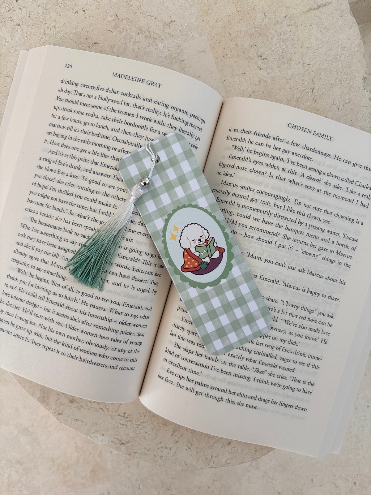 Open book with printed text and a decorative floral bookmark.