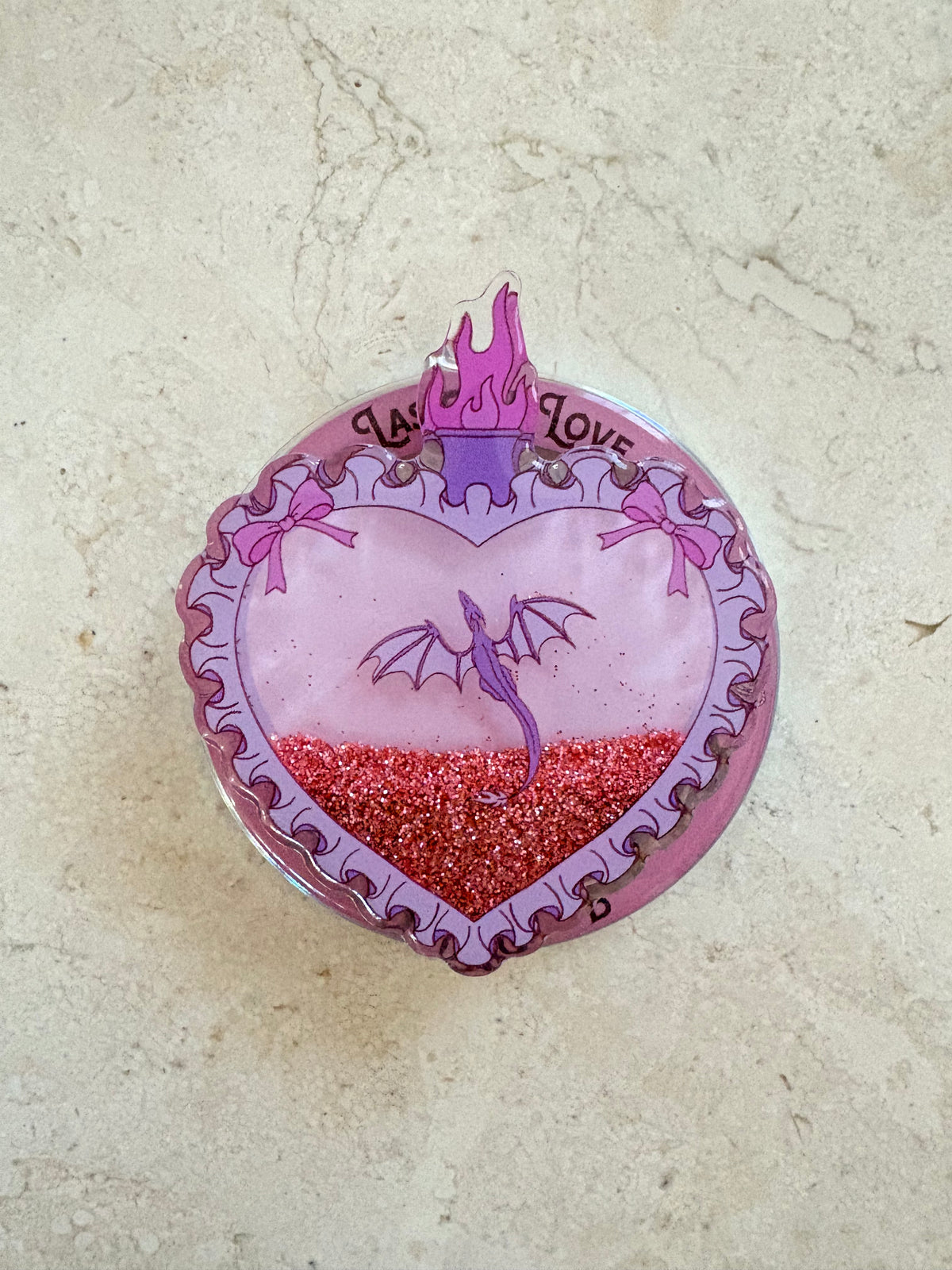 Heart-shaped acrylic shaker keychain with a purple dragon and red glitter.