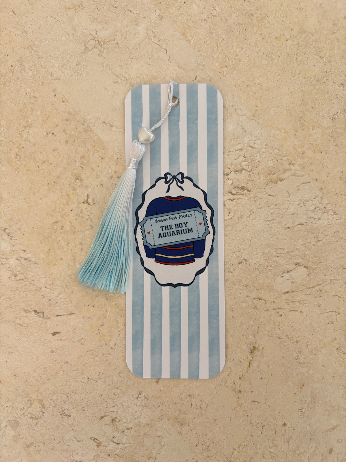 Blue and white striped bookmark with 'The Boy Aquarium' graphic and a light blue tassel