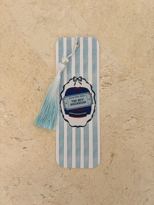 Blue and white striped bookmark with 'The Boy Aquarium' graphic and a light blue tassel
