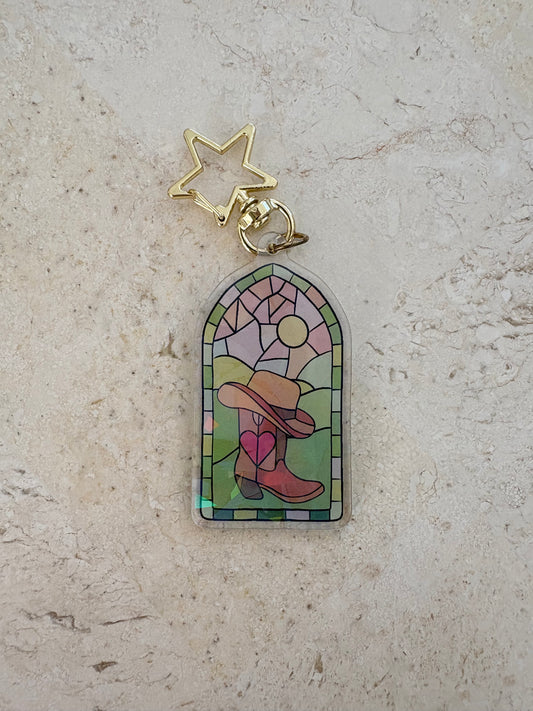 Stained glass style acrylic keychain featuring a cowboy hat and boot with a heart.