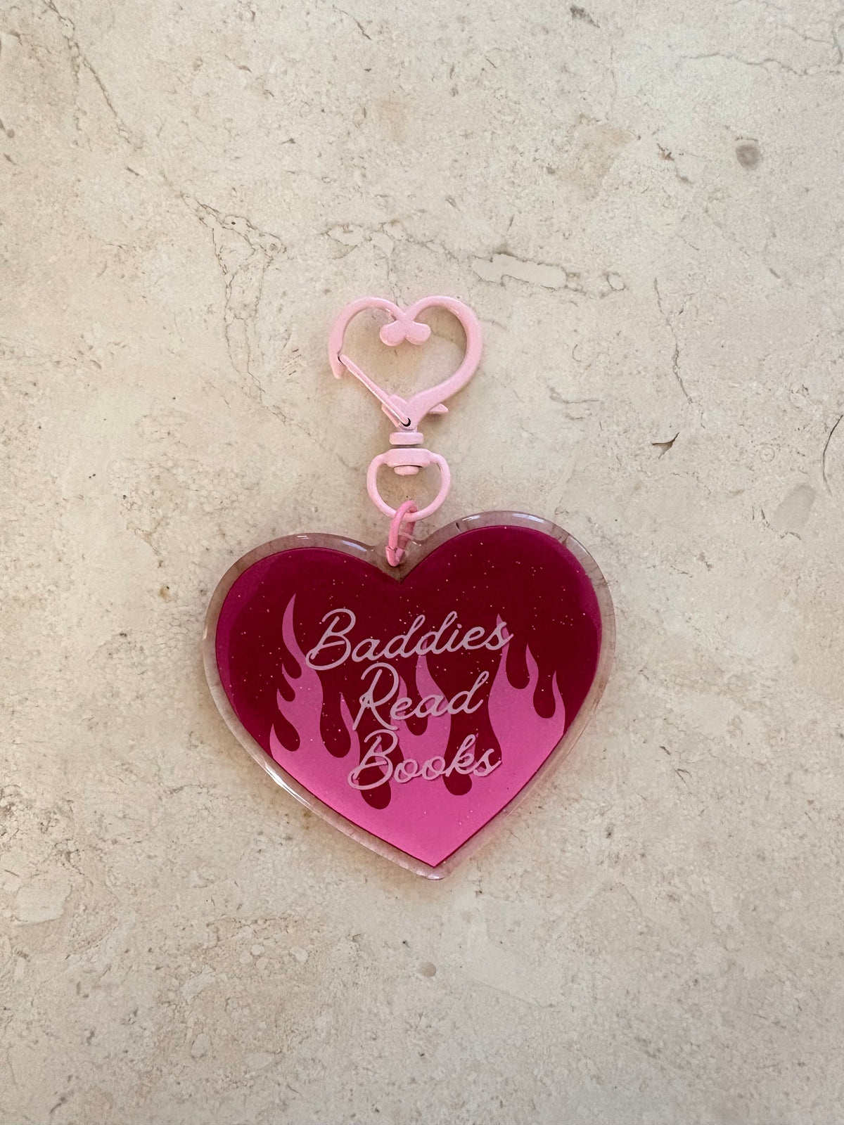 Heart-shaped pink acrylic bookish keychain with 'Baddies Read Books' and flame design