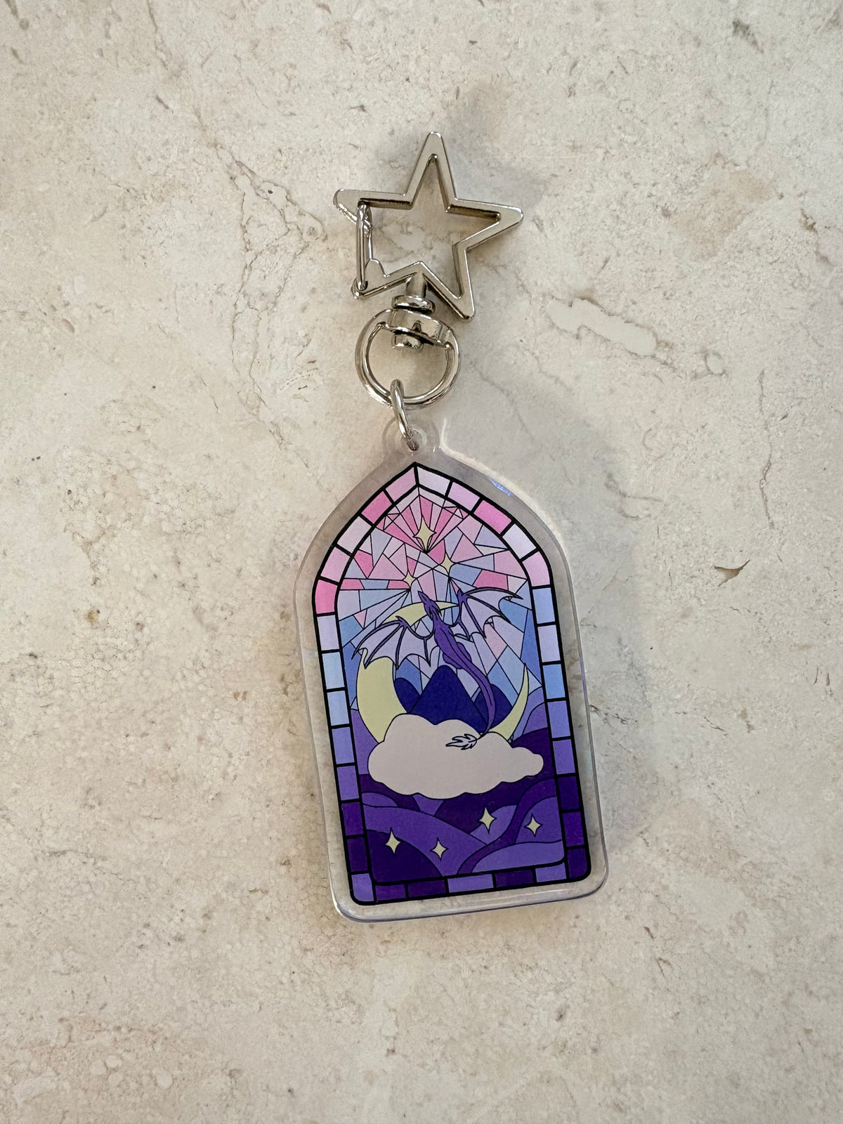 Stained glass style acrylic keychain with a celestial design and star-shaped clasp