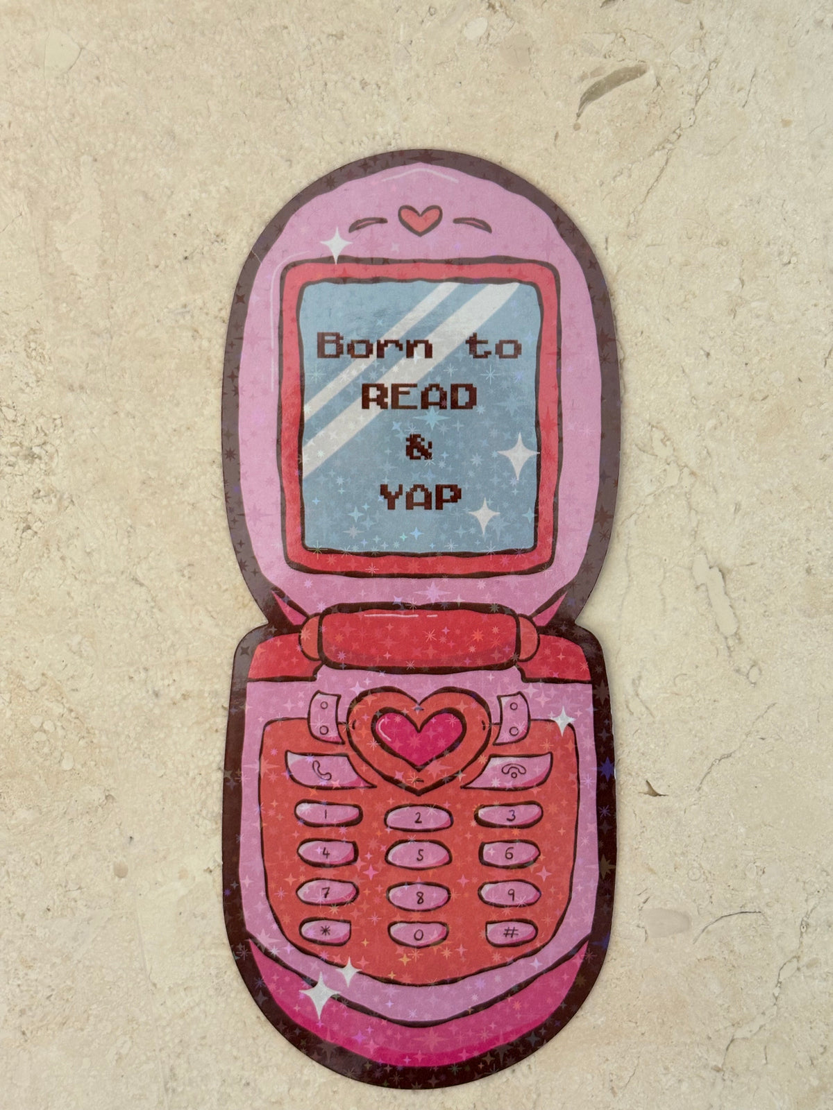 Pink retro flip phone sticker with text 'Born to READ & YAP' and heart details.