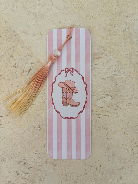 Pink and white striped bookmark with a cowgirl boot illustration and orange tassel