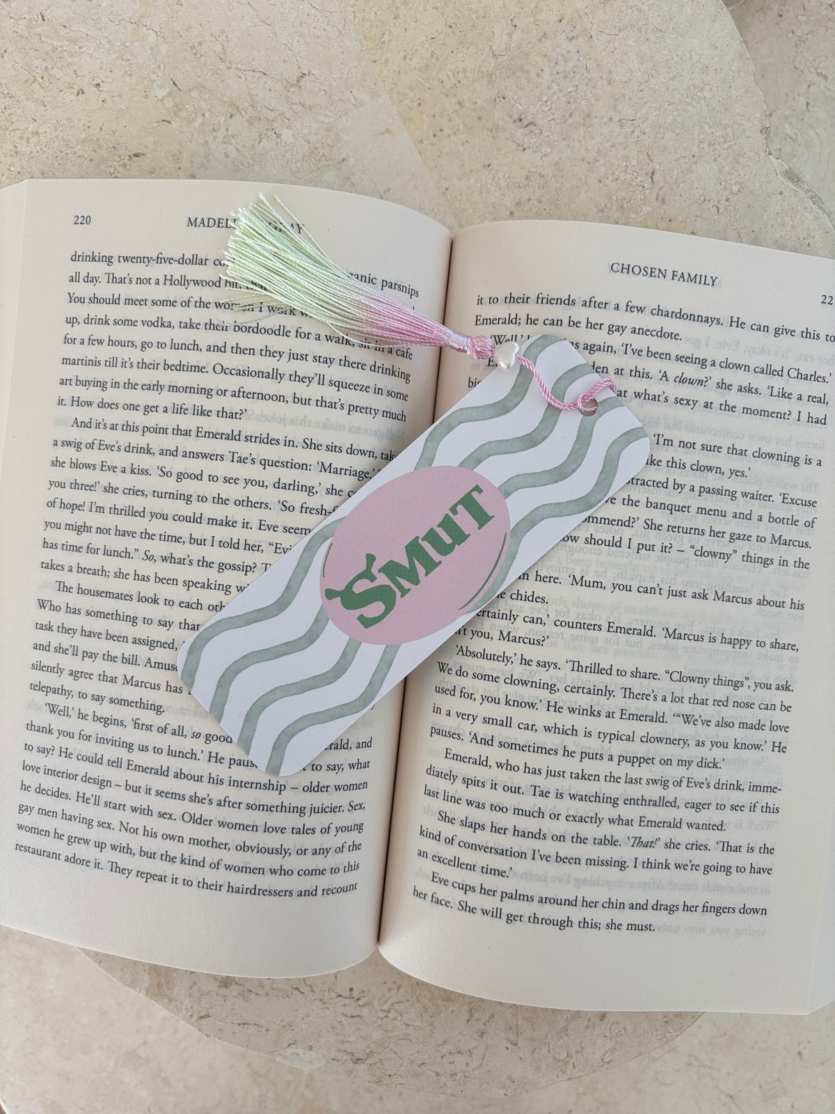 Open romance novel pages with a 'SMUT' bookmark highlighting the text.